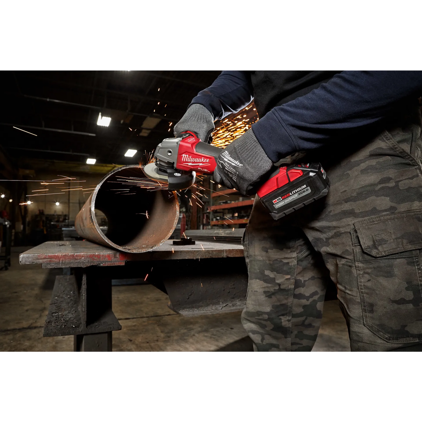 Milwaukee M18 Fuel Grinder 2880-20 in use generating sparks on a metal pipe with visible red and black power tool.