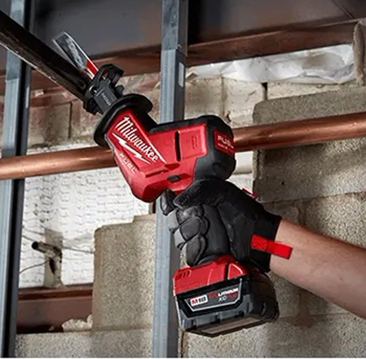Milwaukee M18 Fuel Hackzall red cordless tool cutting metal pipe with gloved hand.