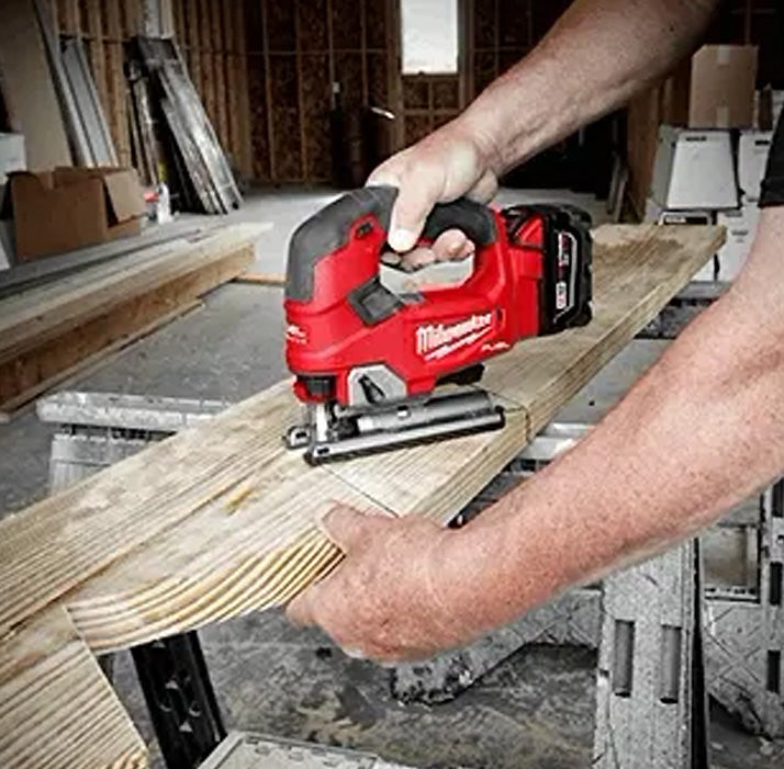 Milwaukee M18 D-Handle Jig Saw cutting wood, handheld red and black power tool.