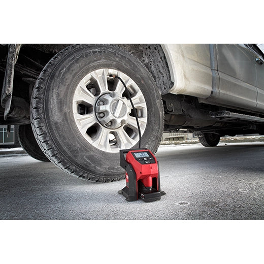 Milwaukee M12 Inflator 2475-20 tool inflating a truck tire with digital display, compact red and black tools.