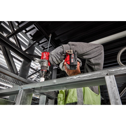 Milwaukee M18 Brushed 1/2 Hammer Drill 2904-20 red and black cordless tool in use on metal framework by worker with gloves.