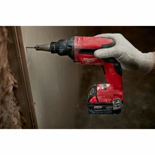 Milwaukee M18 Fuel Drywall Screw Gun 2866-20 red cordless tool held by gloved hand fastening drywall screws.