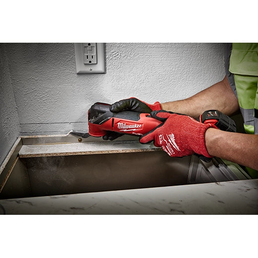 Milwaukee M18 Fuel Multi Tool 2836-20 in red and black, held by hands with red gloves, cutting metal trim on.