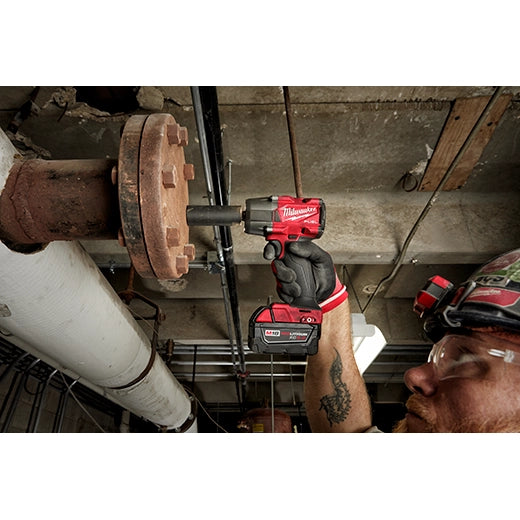 Milwaukee M18 FUEL 3/8" Mid-Torque Impact Wrench 2960-20 red cordless tool held by worker in glove tightening large .