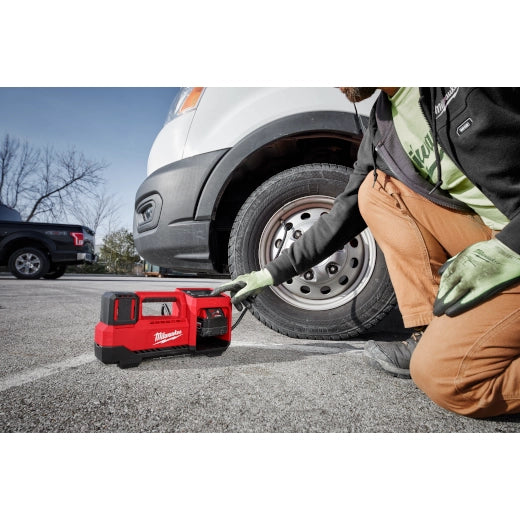 Milwaukee M18 Inflator 2848-20 tool inflating a vehicle tire outdoors.